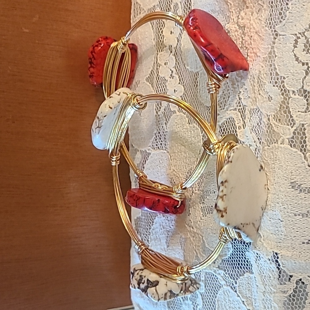 Two stackable wire bracelets in gold color with white and red faux stone